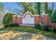 Brick sign identifying the John Wieland Homes community with landscaping and colorful spring flowers at 733 Vinings Estates Se Dr, Mableton, GA 30126