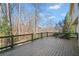 Open wooden deck with black metal railing showcasing a tranquil view of the surrounding wooded landscape at 733 Vinings Estates Se Dr, Mableton, GA 30126