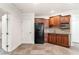 Basement kitchenette featuring wood cabinets, a black refrigerator, and a microwave at 733 Vinings Estates Se Dr, Mableton, GA 30126