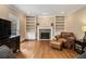 Bright living room featuring hardwood floors, a fireplace, and built-in bookshelves, creating a cozy atmosphere at 2331 Rabbit Farm Cir, Loganville, GA 30052