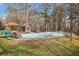 Relaxing pool area with lounge chairs, a small pool house, hot tub, and mature trees at 2331 Rabbit Farm Cir, Loganville, GA 30052