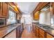 Galley kitchen with brick floors, wood cabinets, and stainless steel appliances at 2506 Emerald Dr, Jonesboro, GA 30236