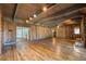 View of a spacious living room showcasing wooden walls, beamed ceiling, and hardwood floors at 2506 Emerald Dr, Jonesboro, GA 30236