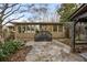 Back exterior of home with stone patio, wooden steps, lush landscaping and covered patio at 630 Oakdale Ne Rd, Atlanta, GA 30307