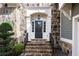 Elegant stone entrance with a black door and wrought iron railing at 185 Windsor Cv, Sandy Springs, GA 30328