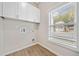 Bright laundry room with modern cabinets, wood-look floors and natural light from the large window at 962 Welch Sw St, Atlanta, GA 30310