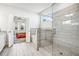 Modern bathroom showcasing a glass-enclosed shower with gray tile surround, soaking tub, and bedroom view at 1809 Hanwoo Ln, Powder Springs, GA 30127