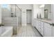 This well-lit bathroom features a glass shower, white cabinets, and tile floors at 1809 Hanwoo Ln, Powder Springs, GA 30127