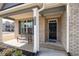 Inviting front porch of a brick home with a bench, dark door and beautiful landscaping at 1809 Hanwoo Ln, Powder Springs, GA 30127