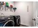 Modern laundry room featuring a front-load washer and dryer set, and shelving for storage at 1809 Hanwoo Ln, Powder Springs, GA 30127