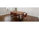 A dining room features hardwood floors, white wainscoting and a wooden table with seating for four at 2005 Haley Wlk Walk, Woodstock, GA 30188