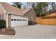 This home features an attached garage with a white door and a paved driveway with space for parking at 2895 Dogwood Creek Pkwy, Duluth, GA 30096