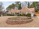 Landscaped front yard with brick retaining wall and driveway leading to attached garage at 2895 Dogwood Creek Pkwy, Duluth, GA 30096