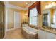 A luxurious bathroom with a soaking tub, separate shower, and granite countertops on vanity at 3786 Turnberry Ct, Duluth, GA 30096