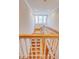 A staircase with wooden steps and white railing leads to the upper level with landing windows at 3786 Turnberry Ct, Duluth, GA 30096