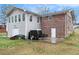 Back of house featuring a brick facade, an attached garage, and a small patio at 4446 Frontier Way, Sugar Hill, GA 30518