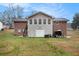 Back of house featuring a brick facade, an attached garage, and a backyard at 4446 Frontier Way, Sugar Hill, GA 30518