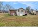 Back of house featuring a brick facade, an attached garage, and a large backyard at 4446 Frontier Way, Sugar Hill, GA 30518