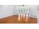 Open living room featuring hardwood floors and bright light from adjoining room at 4446 Frontier Way, Sugar Hill, GA 30518