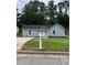 Charming single-story home with light blue siding, black roof, manicured lawn, and inviting front entrance at 6066 Creekford Dr, Lithonia, GA 30058