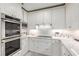 A bright kitchen showcasing stainless steel appliances, modern lighting, and white cabinetry at 750 Park Ne Ave # 14Se, Atlanta, GA 30326