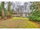 Large backyard with expansive lawn, mature trees, and a multi-level home in the background at 192 Maple Wood Dr, Lawrenceville, GA 30046