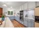 Well-lit kitchen with an island, stainless steel appliances, white cabinets, and hardwood floors at 192 Maple Wood Dr, Lawrenceville, GA 30046