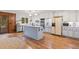 Spacious kitchen features hardwood flooring, stainless steel appliances, an island, and white cabinetry at 192 Maple Wood Dr, Lawrenceville, GA 30046