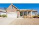 Charming stone home with a manicured lawn and a two-car garage under a clear blue sky at 7040 Tybridge St, Cumming, GA 30040