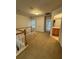 Hallway with neutral carpeting, white banister, and an entrance to the bathroom at 1696 Tailmore Ln, Lawrenceville, GA 30043