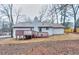 Back exterior view showcasing the home with a brick chimney and deck in a serene setting at 2370 Old Mill Sw Dr, Conyers, GA 30094