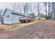 A spacious backyard featuring a wooden fence, deck, and a charming single-Gathering home surrounded by mature trees at 2370 Old Mill Sw Dr, Conyers, GA 30094