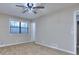 Spacious bedroom featuring carpet, neutral decor, a ceiling fan, and a window with outside views at 2370 Old Mill Sw Dr, Conyers, GA 30094