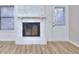 Living room featuring white fireplace, new floors, natural light, and access to backyard at 2370 Old Mill Sw Dr, Conyers, GA 30094