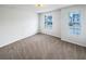 This bedroom features plush carpeting and two bright windows overlooking the neighborhood at 180 Fieldview Ln, Covington, GA 30016