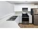 Bright kitchen features white cabinetry, stainless steel appliances, and laminate flooring at 180 Fieldview Ln, Covington, GA 30016