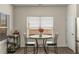 Bright dining area features a round table, two chairs, and a bar cart near the window at 9032 Jim Purcell Dr, Covington, GA 30014