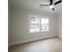 Sun-filled bedroom with neutral walls, hardwood floors, ceiling fan and a window view of a charming home at 3128 Cedar St, Scottdale, GA 30079