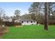 Spacious backyard featuring a well-maintained lawn, wooden fence and a charming dog house at 3566 Dorris Cir, Douglasville, GA 30135