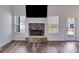 Close-up of a stone fireplace with white trim and a mounted TV in a light-filled living room at 429 Mulberry Rock Road, Temple, GA 30179