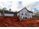 Expansive backyard view showcasing the modern farmhouse design with white siding and a gray brick foundation at 472 Price Rd, Carrollton, GA 30116