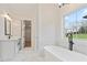 Bright bathroom featuring a soaking tub, glass enclosed shower and a vanity with modern fixtures at 472 Price Rd, Carrollton, GA 30116