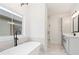 Bright bathroom featuring a soaking tub, glass-enclosed shower, and vanity with modern fixtures at 472 Price Rd, Carrollton, GA 30116