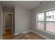 Bright bedroom featuring neutral walls, trim, natural light from the window, and doorway leading to another room at 472 Price Rd, Carrollton, GA 30116