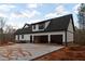 Two-car garage and extended driveway provide ample parking for this stylish white and black farmhouse at 472 Price Rd, Carrollton, GA 30116