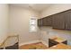 A new laundry room with dark cabinets above a washer/dryer, in progress at 472 Price Rd, Carrollton, GA 30116