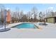 A tranquil swimming pool with chairs, umbrellas, and natural landscaping at 472 Price Rd, Carrollton, GA 30116