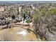 Stunning aerial view of estate home with pond, mature trees, and lush landscaping at 11180 West Rd, Roswell, GA 30075