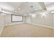 Finished basement with carpet, recessed lighting, and blank projection screen at 11180 West Rd, Roswell, GA 30075
