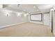 Spacious basement featuring carpeting, overhead lights, and a blank projector screen at 11180 West Rd, Roswell, GA 30075